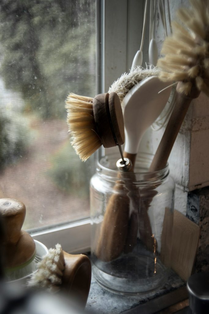 Brosse en bois posée dans un récipient en verre pour le nettoyage