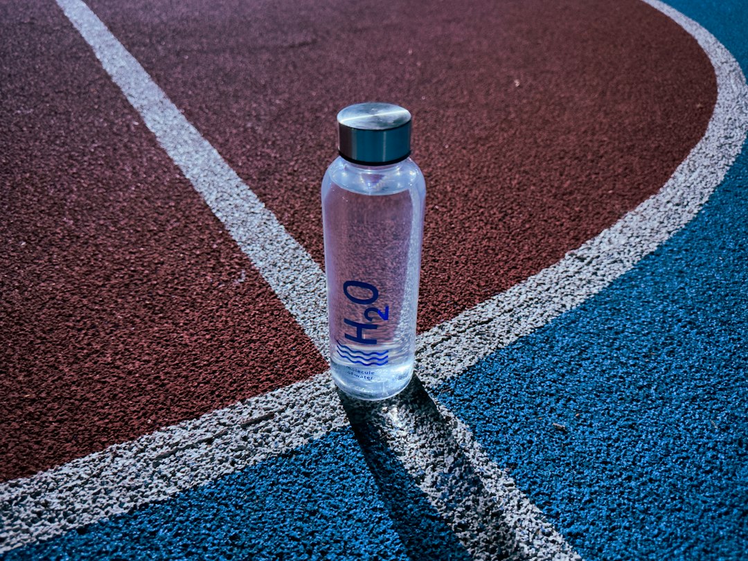 Gourde transparente posée sur une piste d’athlétisme