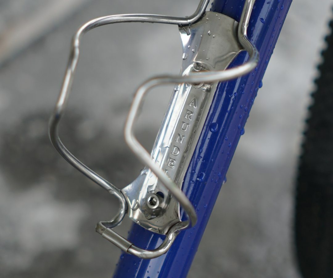 Porte-bidon métallique sur un cadre de vélo bleu